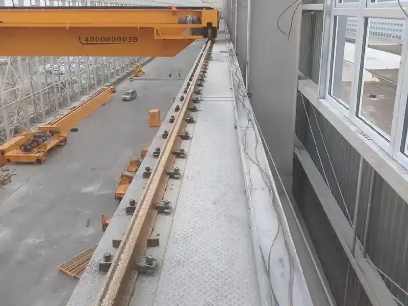 overhead crane rail system installed on steel beams in factory warehous